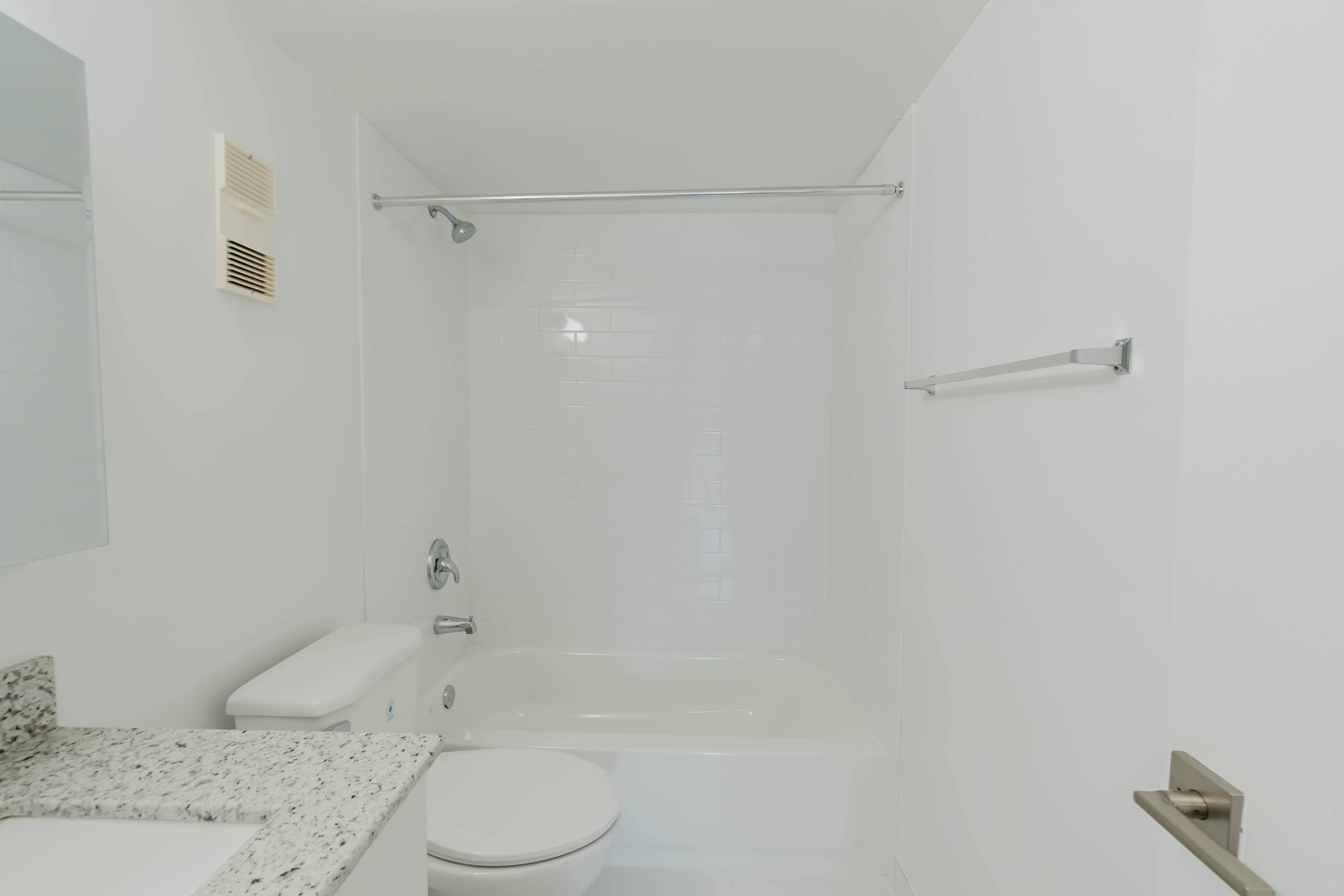 A white bathroom with a toilet, sink, and bathtub.